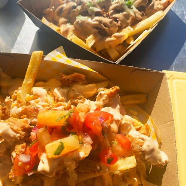 Savory loaded fries with cheese, gravy, and fresh toppings at Taranaki Beer Festival, featuring local craft beers and delicious food.