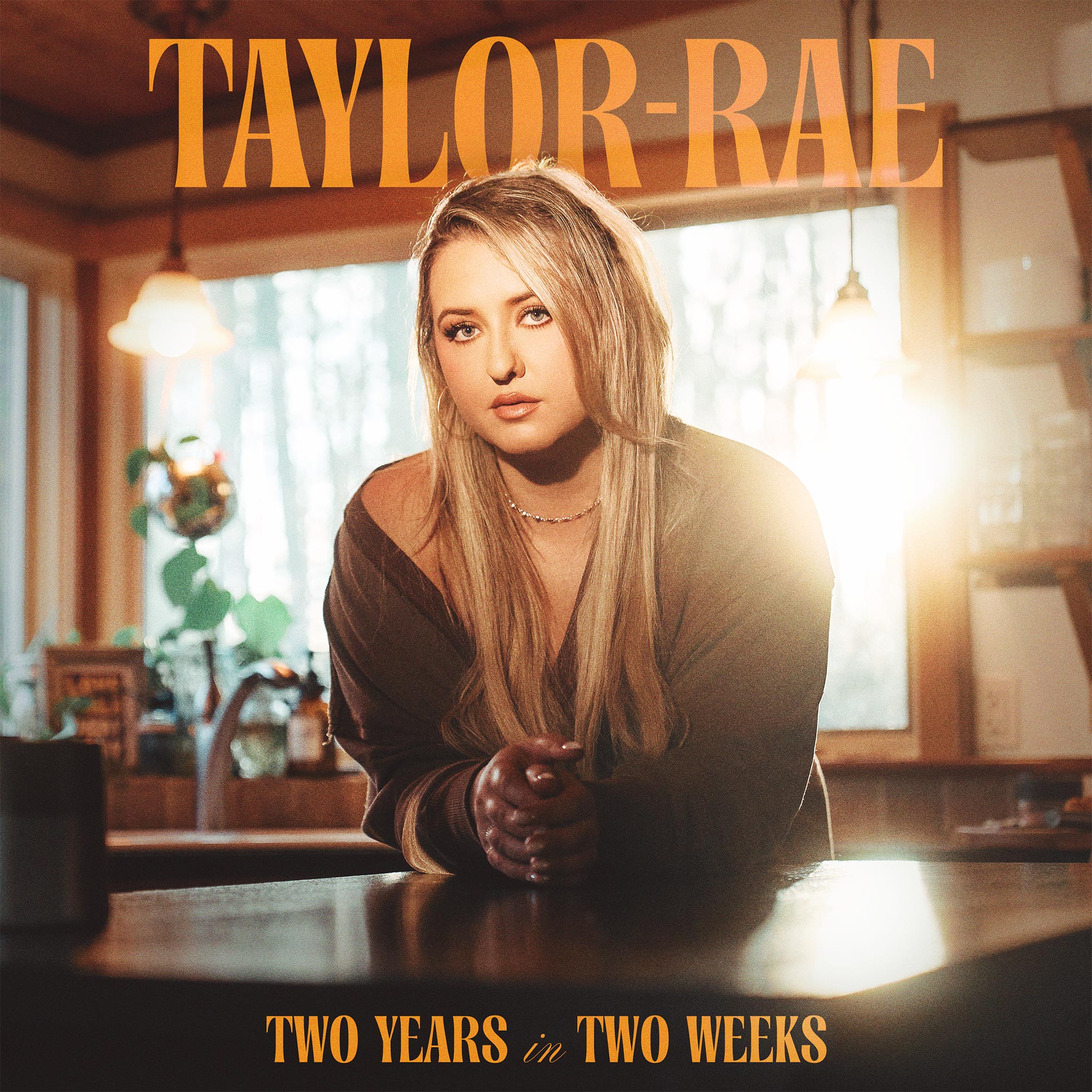 Portrait of Taylor-Rae from the "Bittersweet" album, showcasing her in a warm, inviting environment with natural light, emphasizing her musical style and emotional expression.