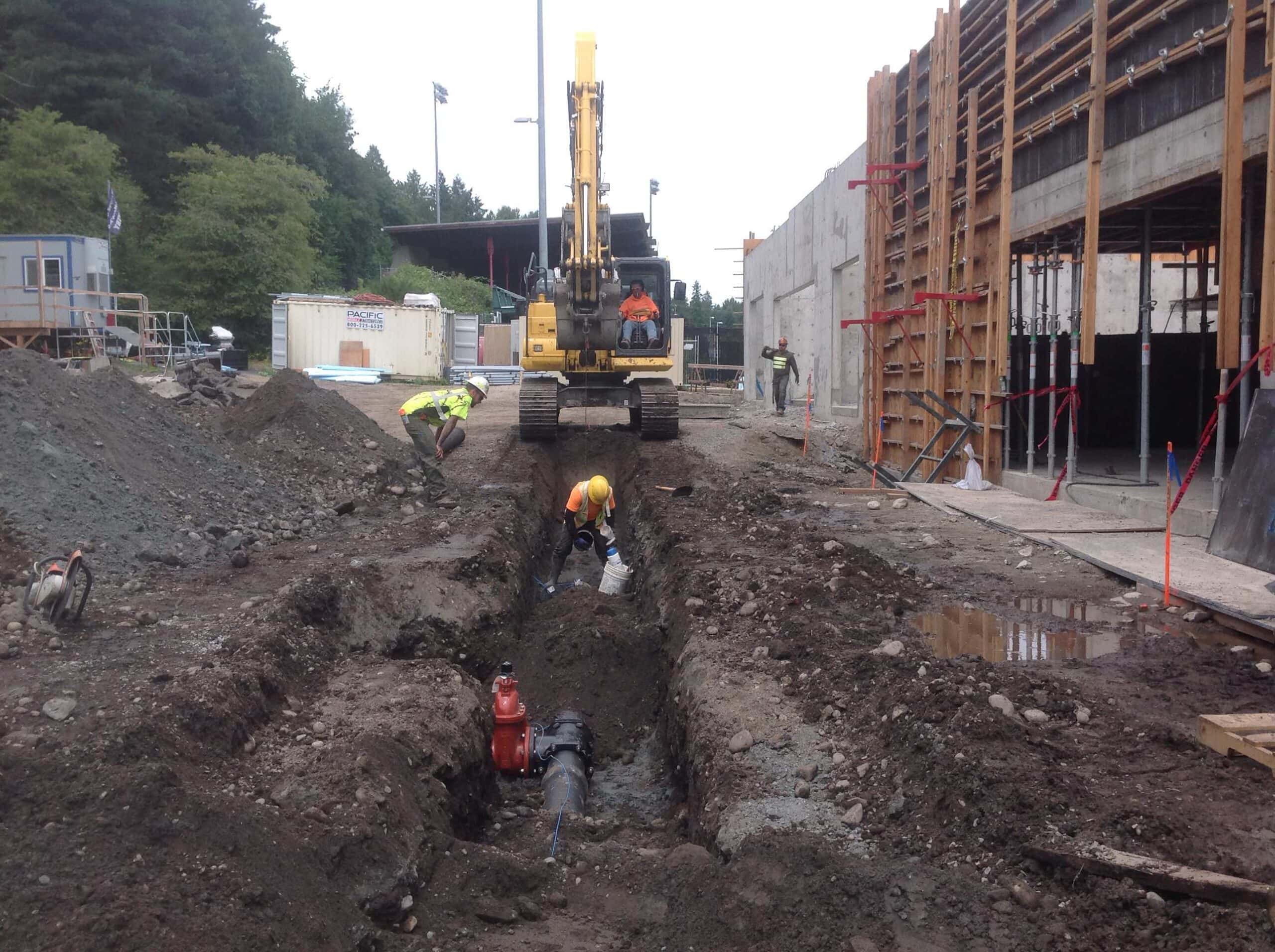 Team Nelson crew installing underground utility pipe in trench, Puget Sound area