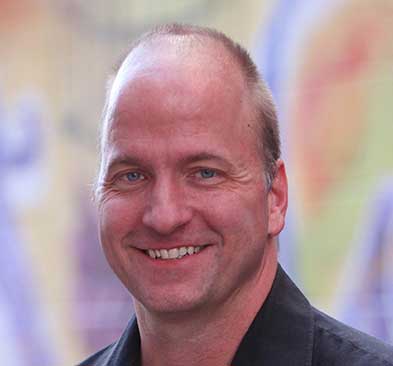 Portrait of Josh Barsch smiling at TESSA event, professional headshot.