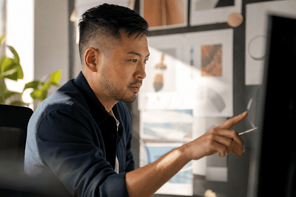 Focused man using digital tablet in modern office environment.