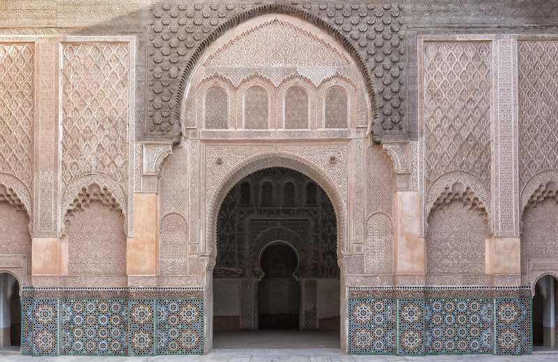 Fachada de una puerta de estilo marroquí con detalles ornamentales y azulejos coloridos.