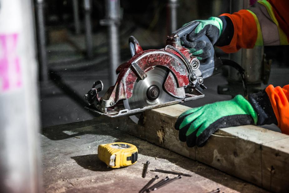 Cutting timber with a circular saw at Te Tumu Kāinga construction site, promoting affordable housing solutions in New Zealand.