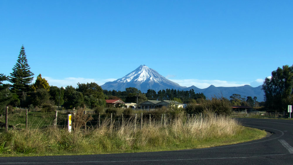 Serene rural landscape near Te Tumu Kāinga with Mount Taranaki in the background, showcasing New Zealand’s natural beauty and community.