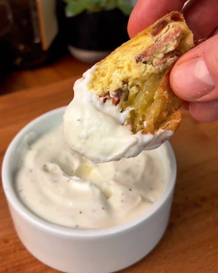 creamy garlic dijon yogurt sauce in a bowl and on a bite of bacon, egg, cheese dumpling