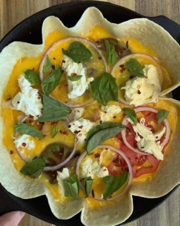 a tomato burrata tortilla quiche in-progress, filled with egg yolk, red onion, fresh basil, burrata and tomato
