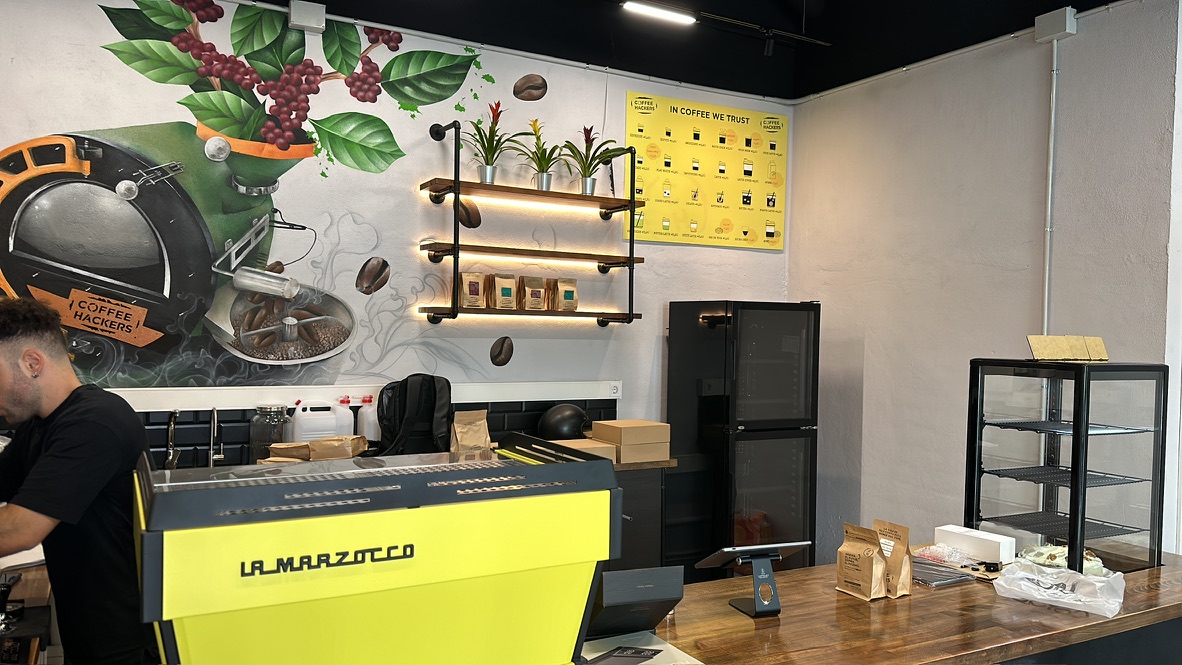 La Marzocco amarilla y mural artístico en la barra