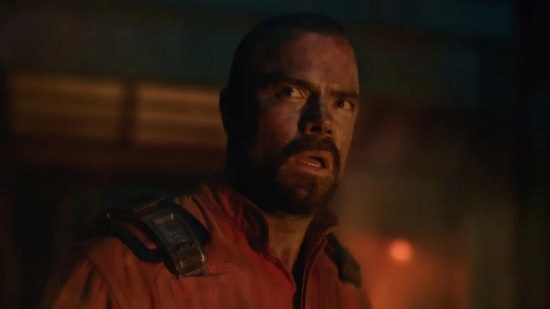 A man with a distressed expression in a dark, intense scene from a horror or sci-fi game.