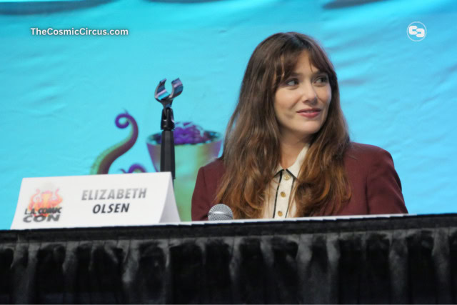 Elizabeth Olsen on stage with a blue background