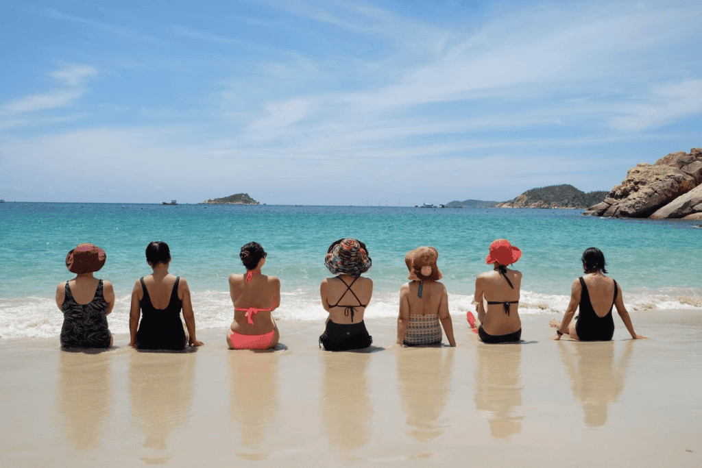 7 cô gái ngồi quay lưng lại, phía trước là biển và núi ở Bình Lập