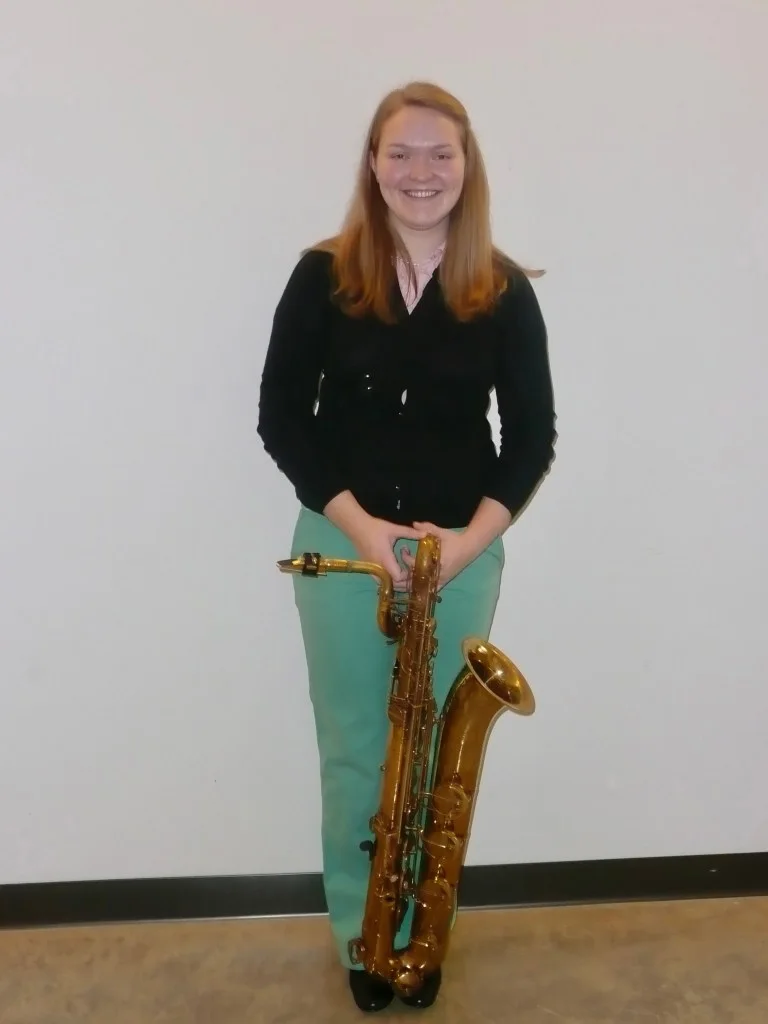 Photo of Grace in college with her baritone saxophone