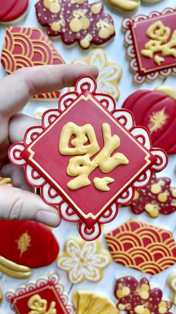 cookie decorated with royal icing lettering in chinese 