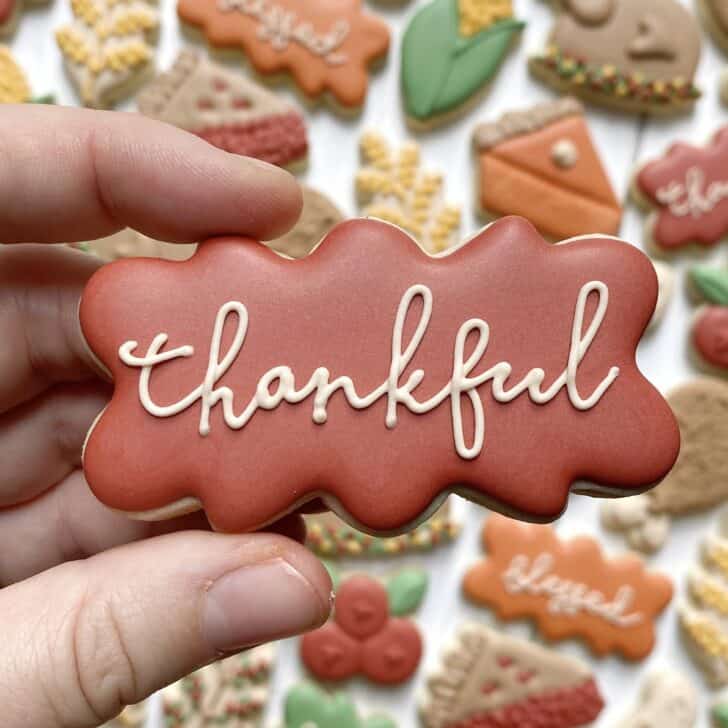 photo of writing with royal icing on a cookie: script saying THANKFUL