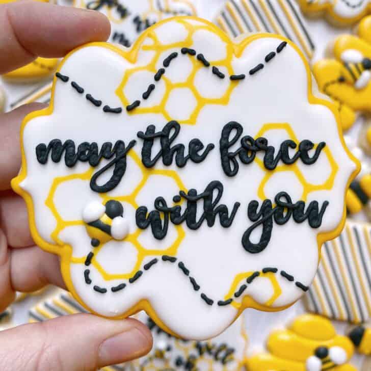 photo of cookie decorated with royal icing using peony blooms font saying MAY THE FORCE BEE WITH YOU