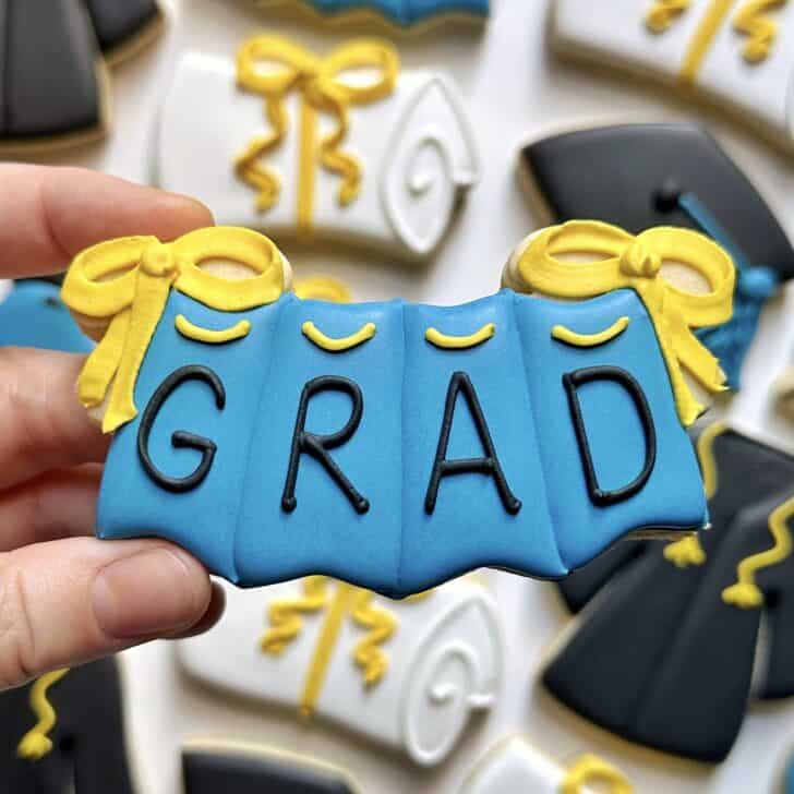photo of writing with royal icing on a cookie: simple line saying GRAD