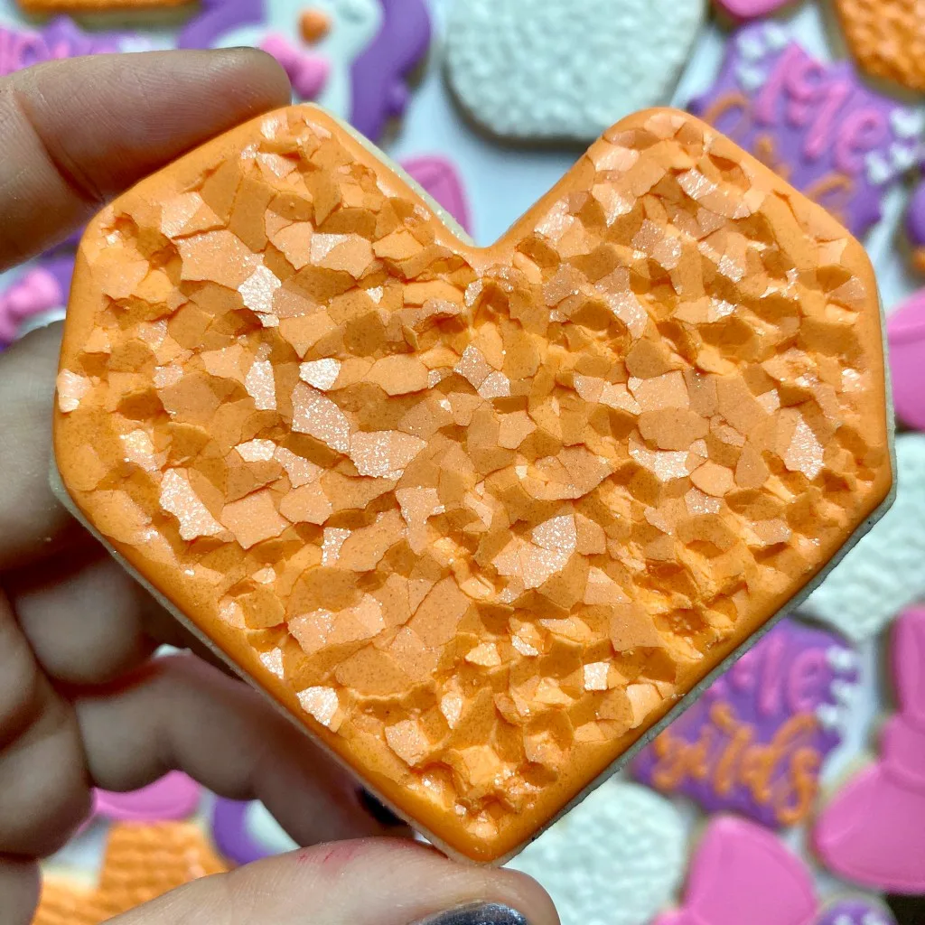photo of orange heart cookies decorated with royal icing