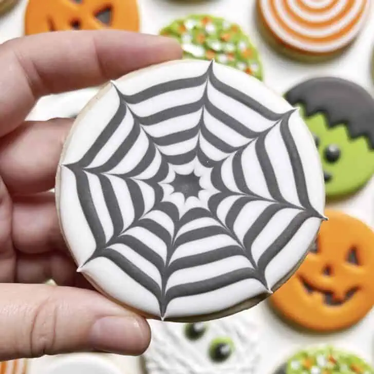 photo of circle spider web halloween cookie decorated with royal icing
