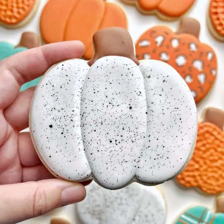 white splatter Pumpkin Cookies with royal icing