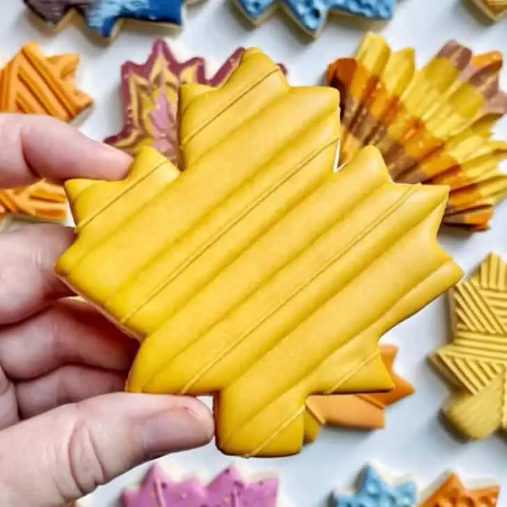 yellow lines maple leaf cookies decorated with royal icing 