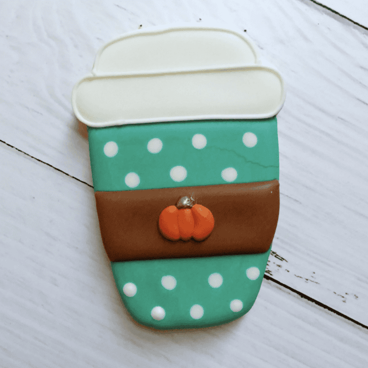 fall coffee cup cookie decorated with royal icing and has a crack on the icing