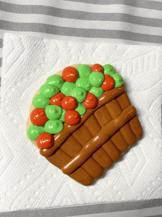 Step-by-step decorating instructions for how to decorate Apple basket cookies with royal icing