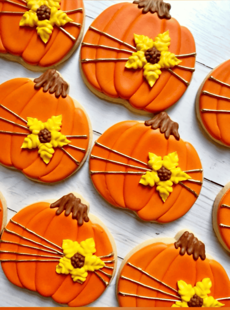 pumpkin shaped cookies decorated with royal icing