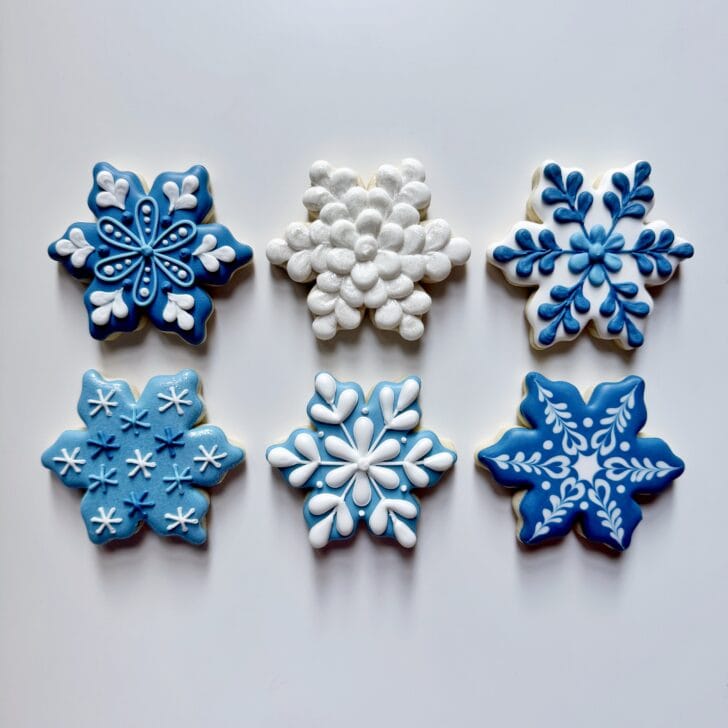 6 snowflake cookies decorated with royal icing 
