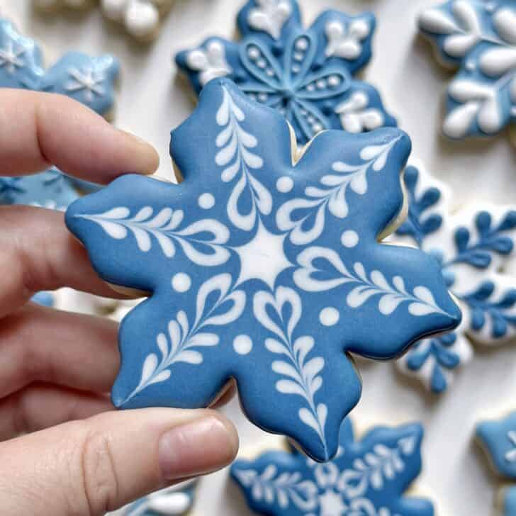 dark blue snowflake cookie decorated with royal icing 