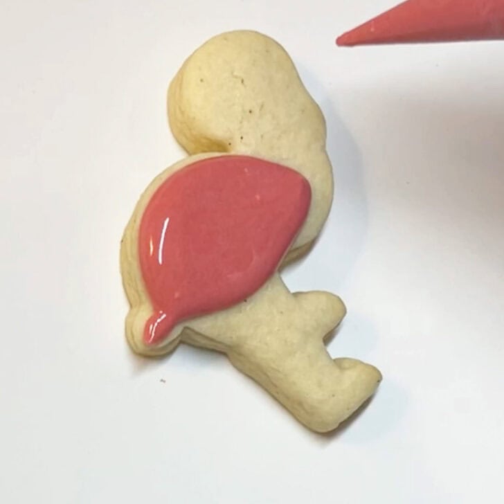Step-by-step instructions for how to decorate flamingo cookies with royal icing