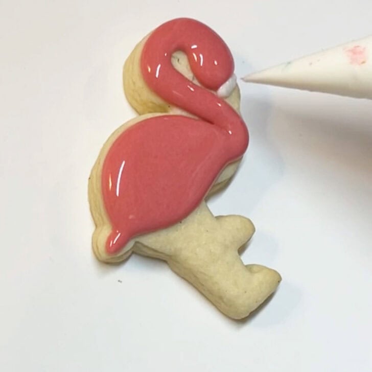 Step-by-step instructions for how to decorate flamingo cookies with royal icing
