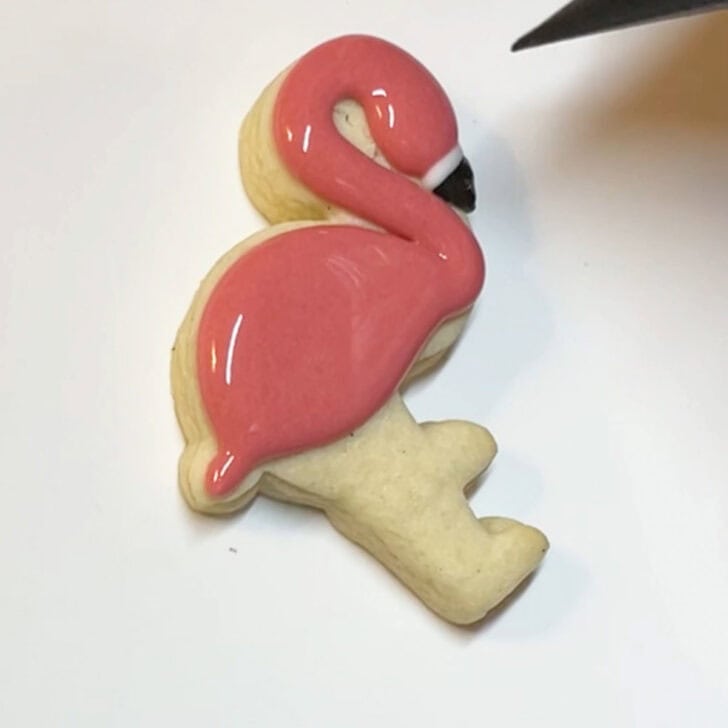 Step-by-step instructions for how to decorate flamingo cookies with royal icing