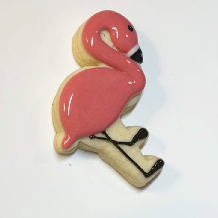 Step-by-step instructions for how to decorate flamingo cookies with royal icing