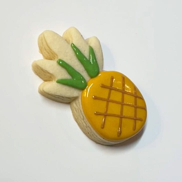 Step-by-step instructions for decorated pineapple cookies with royal icing