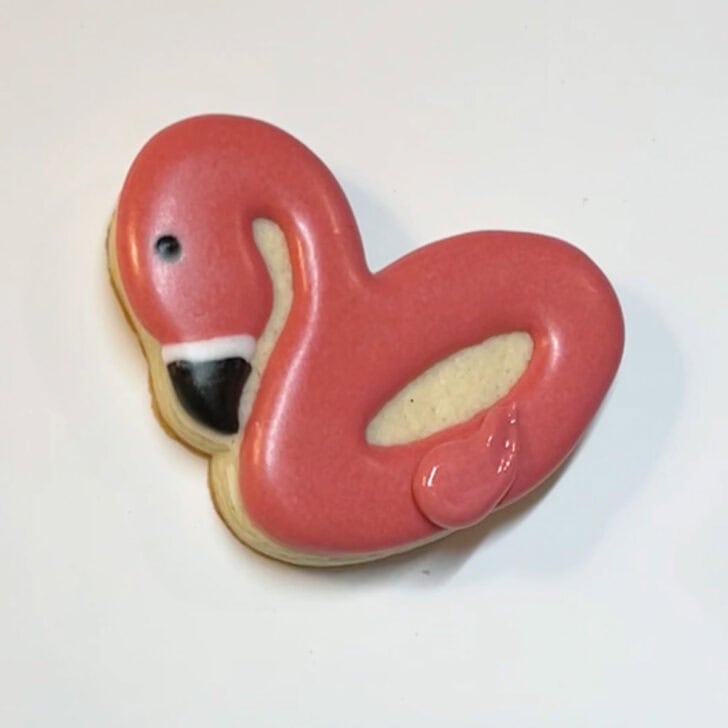 Step-by-step instructions for how to decorate flamingo pool float cookies with royal icing