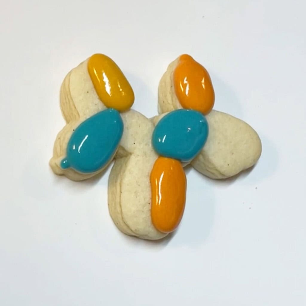 A cookie with colorful icing and a balloon.