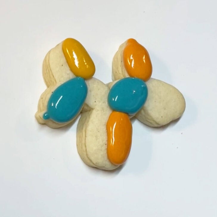 A cookie with colorful icing and a balloon.