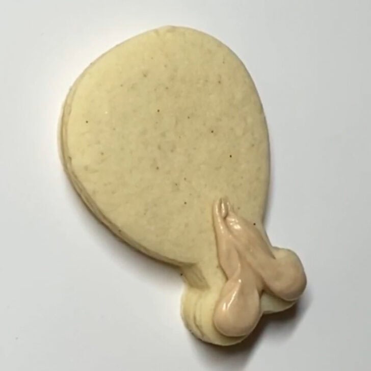 Step-by-step decorating instructions for how to decorate mini turkey leg cookies with royal icing