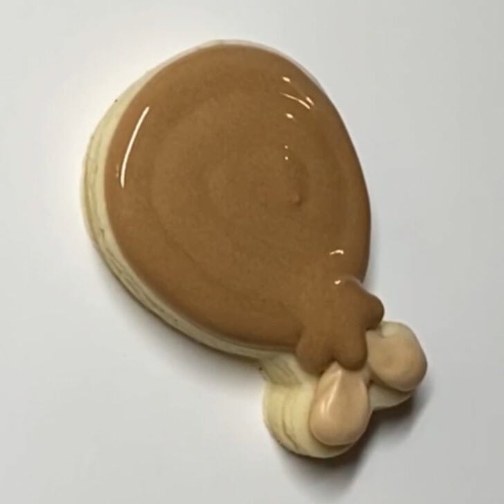 Step-by-step decorating instructions for how to decorate mini turkey leg cookies with royal icing