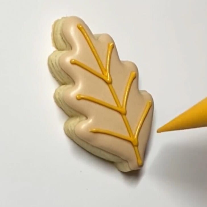 Step-by-step decorating instructions for how to decorate mini wheat sugar cookies with royal icing