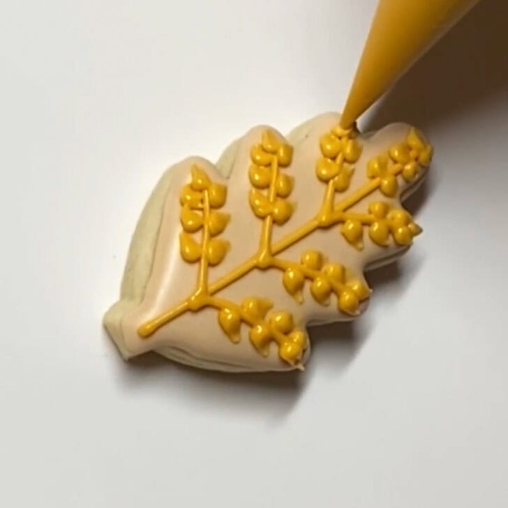 Step-by-step decorating instructions for how to decorate mini wheat sugar cookies with royal icing