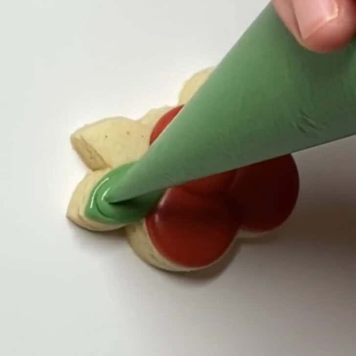 Step-by-step decorating instructions for how to decorate mini cranberry sugar cookies with royal icing