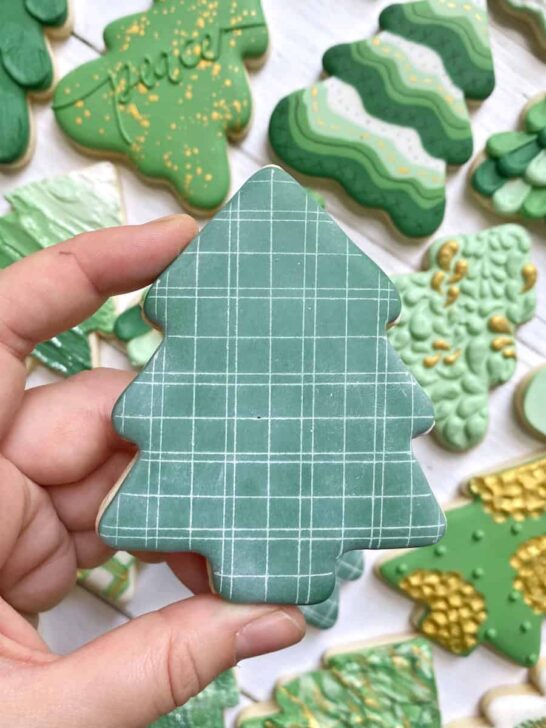etched plaid Christmas tree cookies decorated with royal icing