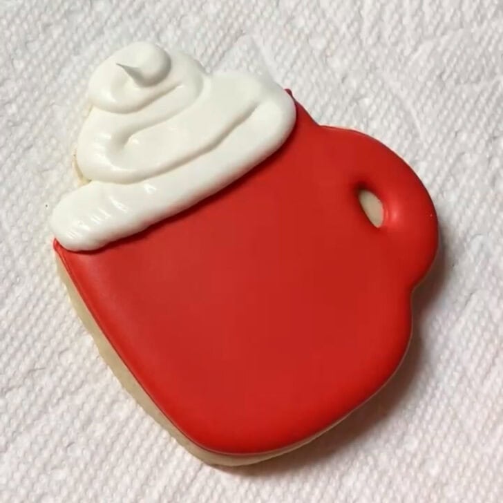 Step-by-step decorating instructions for how to decorate christmas mug cookies with royal icing