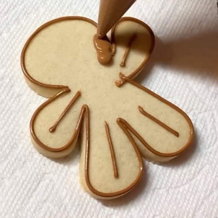 Stop by stop decorating instructions for how to decorate gingerbread man sugar cookies with royal icing