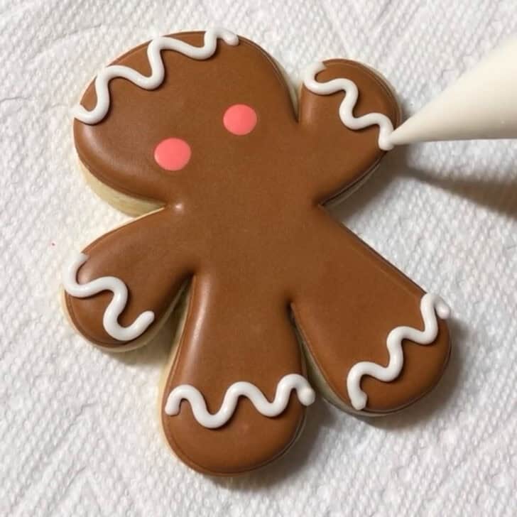 Stop by stop decorating instructions for how to decorate gingerbread man sugar cookies with royal icing