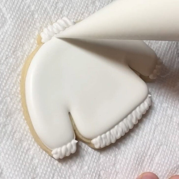 step by step decorating instructions for how to decorate sweater cookies with royal icing