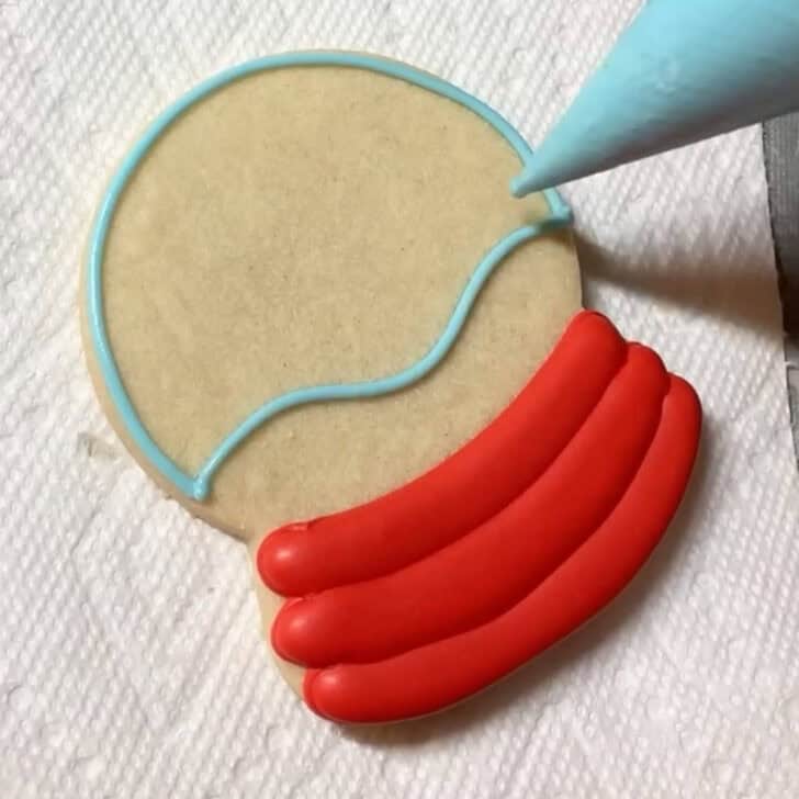 Step by step decorating instructions for how to decorate snow globe cookies with royal icing