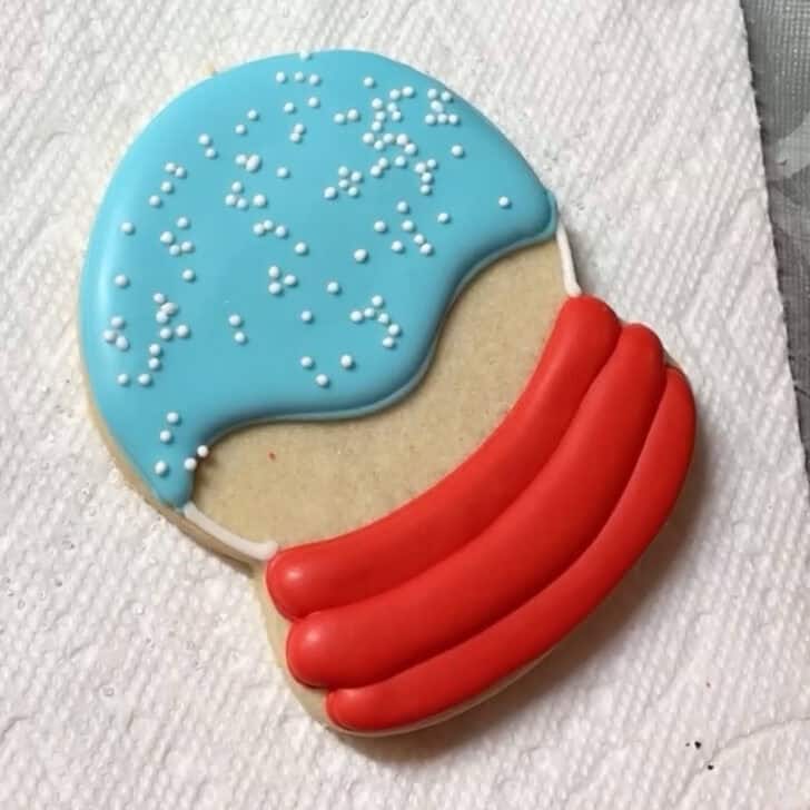 Step by step decorating instructions for how to decorate snow globe cookies with royal icing