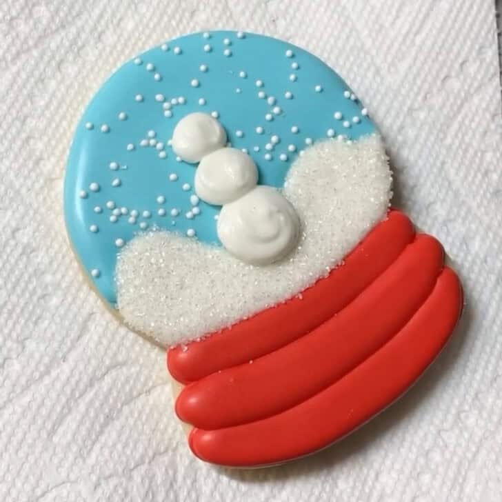 Step by step decorating instructions for how to decorate snow globe cookies with royal icing