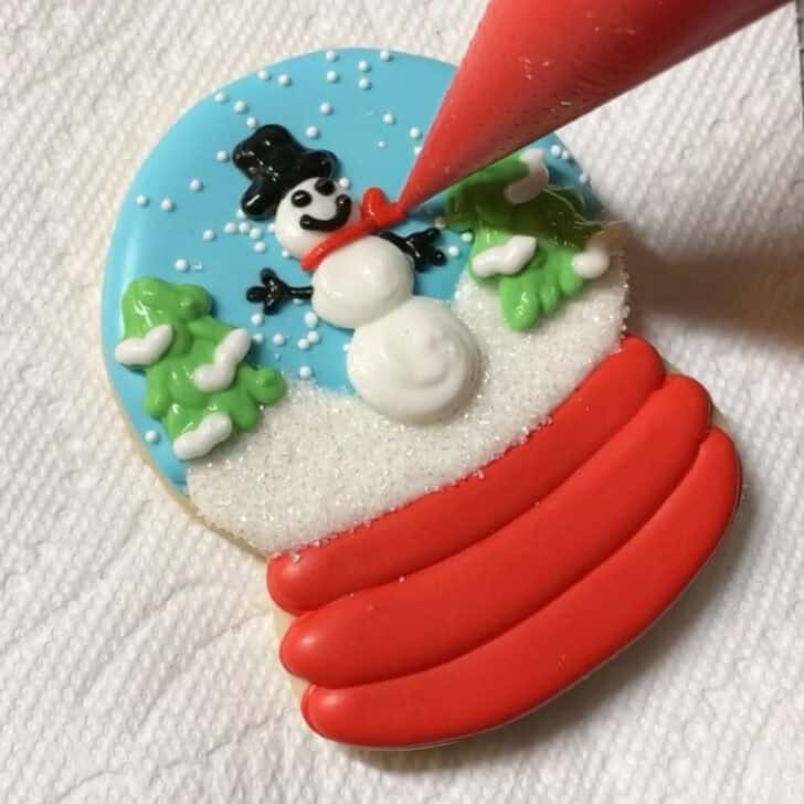 Step by step decorating instructions for how to decorate snow globe cookies with royal icing